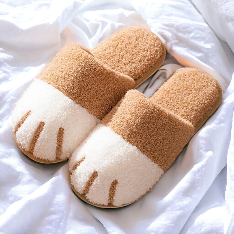 Beige plush slippers designed like cat paws, soft and warm for indoor use.