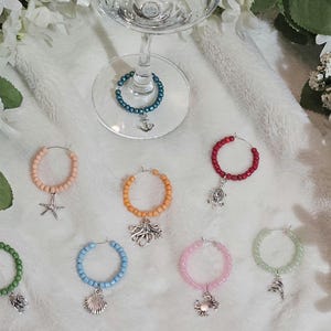 Peut inclure: Ensemble de 8 charmes de verre à vin en perles colorées avec divers charmes de créatures marines. Les charmes comprennent une étoile de mer, une pieuvre, une tortue, un crabe et une ancre.