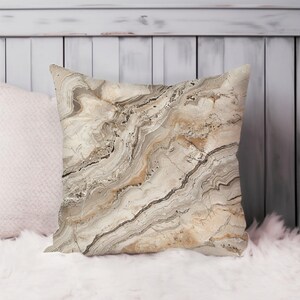 May include: A decorative throw pillow with a beige and brown marble pattern. The pillow is made of a soft, comfortable fabric and is perfect for adding a touch of style to any room.