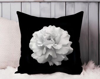 May include: Black and white throw pillow with a large white flower in the center.