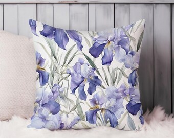 May include: A white cushion with a purple and green floral pattern. The cushion features a watercolour design of iris flowers.