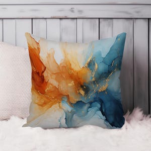 May include: A decorative cushion with an abstract design featuring swirling blue, orange, and gold paint.