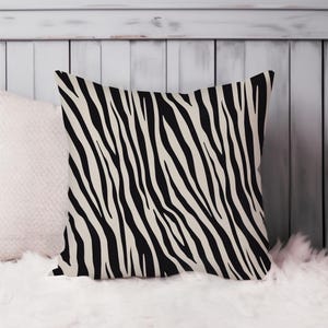 May include: A black and white zebra print throw pillow. The pillow is made of a soft, comfortable fabric and has a zipper closure.