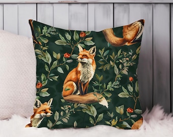 May include: Square decorative pillow with a dark green background featuring a repeating pattern of foxes, leaves, and red flowers. The foxes are depicted in shades of orange, brown, and white. The pillow is placed on a white surface.