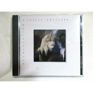 Könnte beinhalten: Eine CD-Hülle mit dem Album "Recollection" von Leslie Phillips. Das Cover zeigt eine Frau mit blonden Haaren, die nach oben blickt. Der Text "LESLIE PHILLIPS" und "RECOLLECTION" ist auf dem Cover abgedruckt.