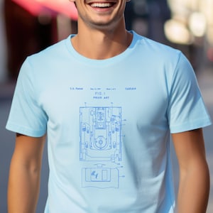 May include: A light blue t-shirt with a blue and white diagram of a floppy disk drive and a floppy disk. The diagram includes the text "FIG. I PRIOR ART" and "U.S. Patent May 13, 1997 Sheet 1 of 4 5,629,819".