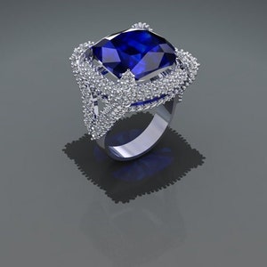 May include: A silver ring with a large, square-shaped blue sapphire gemstone surrounded by smaller white gemstones.