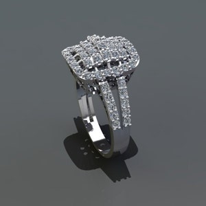 May include: A silver ring with a large, square-shaped diamond cluster set in the center. The ring has a band that is set with smaller diamonds.