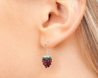 May include: Silver dangle earrings with a purple and green enamel blackberry charm.