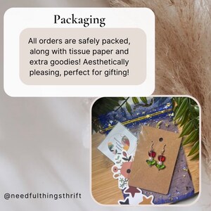 May include: Aesthetic packaging with tissue paper and extra goodies. The image includes a pair of red apple earrings with green leaves and white pearls. The packaging also includes a small card and a blue mesh bag.