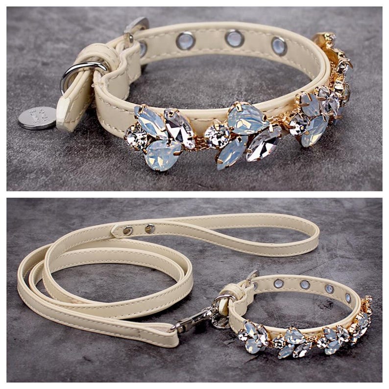 May include: A cream-colored leather dog collar and leash set with a decorative crystal embellishment. The collar and leash are both accented with gold-toned hardware.