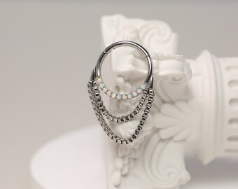 Può includere: Gioiello per il corpo in argento con un cerchio circolare e tre catene pendenti adornate con pietre di opale bianche.