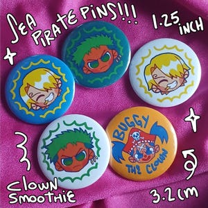 May include: A collection of five round pins with cartoon pirate character designs. The pins are 1.25 inches in diameter and feature characters with various hair colors and expressions. Text on the pins includes "Sea Pirate Pins!!!", "Buggy The Clown", and "Clown Smoothie".