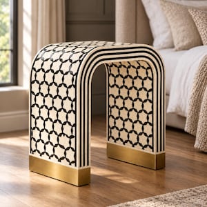 May include: An arched side table featuring a cream and black geometric star pattern on its top and sides, accented by black vertical stripes along the inner curve and finished with solid brass-toned metal bases on each of the two feet.