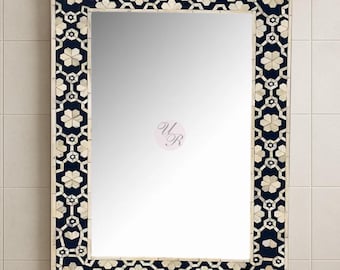May include: Rectangular mirror with a decorative frame. The frame features a repeating pattern of white floral shapes on a dark blue background. The mirror is designed for wall mounting and adds a touch of elegance to any space.