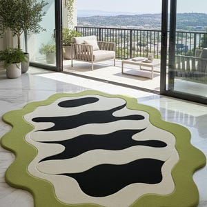 May include: A modern area rug with an abstract design. The rug features a wavy pattern in black and off-white, framed by a light green border. The rug is placed on a marble floor, with a balcony and outdoor view in the background.