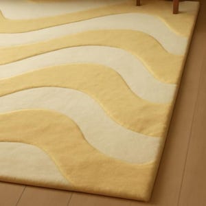 Bottom view of Hand tufted wool rug with soft butter yellow and cream wavy pattern.