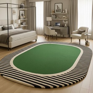 K&ouml;nnte beinhalten: Ovaler Teppich mit gr&uuml;nem Zentrum, cremefarbenem Rand und schwarz-wei&szlig; gestreiftem Rand. Der Teppich befindet sich in einem Schlafzimmer mit Bett, Schreibtisch und St&uuml;hlen.
