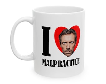 May include: White ceramic mug with a black "I heart Malpractice" design. The heart features a photo of actor Hugh Laurie as Dr. Gregory House from the TV show House.