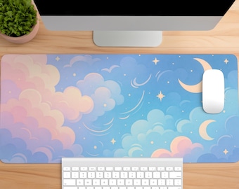 May include: A rectangular desk mat featuring a sky-themed illustration with soft pink, lavender, and blue clouds. The design includes a crescent moon and scattered four-pointed stars against a gradient blue background, providing a smooth surface.