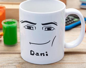 May include: White ceramic mug with a black and white illustration of a face with the name "Dani" printed below.
