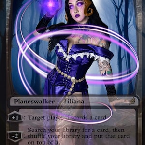 Può includere: Una carta di Magic: The Gathering con Liliana Vess, una planeswalker. La carta ha uno schema di colori viola e oro e presenta una donna con capelli scuri e occhi viola. Il testo della carta recita: "Liliana Vess, Planeswalker - Liliana. +1: Il giocatore bersaglio scarta una carta. -2: Cerca nella tua biblioteca una carta, poi mescola la tua biblioteca e metti quella carta in cima. -8: Metti tutte le carte creatura in tutti i cimiteri in gioco sotto il tuo controllo."
