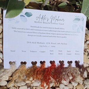 May include: A color card for Adele's Mohair, featuring samples of boucle yarn in various shades. The card includes text describing the yarn's composition (78% Kid Mohair, 13% Wool, 9% Nylon) and origin. Colors range from light beige to dark brown.