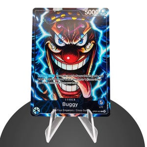 Könnte beinhalten: Eine Sammelkarte mit einem Cartoon-Clown mit einer großen roten Nase, einem breiten Grinsen und blauen Blitzeffekten. Die Karte trägt die Aufschrift "Buggy" und enthält Spieltext. Die Karte wird auf einem transparenten Acrylständer präsentiert.