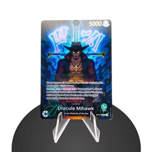 Peut inclure: Une carte à collectionner représentant Dracule Mihawk des Sept Grands Corsaires. La carte a un fond bleu et noir avec une illustration d'un homme portant un chapeau noir. La carte est présentée sur un présentoir en plastique transparent.