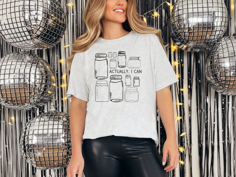 May include: A gray t-shirt with a graphic of jars and the text "Actually, I can".