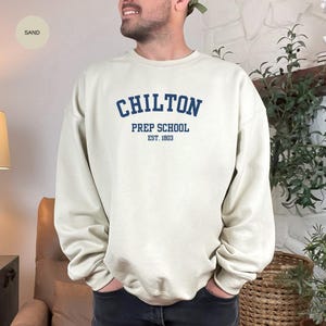 May include: A sand-colored sweatshirt with the text "Chilton Prep School Est. 1803" in blue.