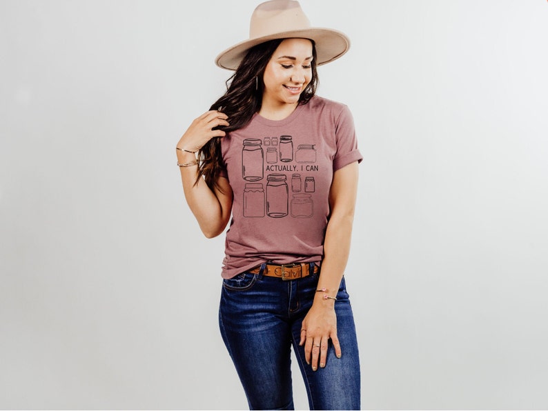 May include: A mauve t-shirt with a graphic of jars and the text "Actually, I can".