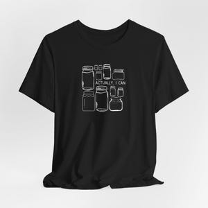 May include: Black t-shirt with a white graphic of jars and the text "Actually, I can".