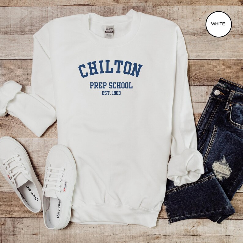 May include: White long-sleeved sweatshirt with the text "Chilton Prep School Est. 1803" in blue lettering.