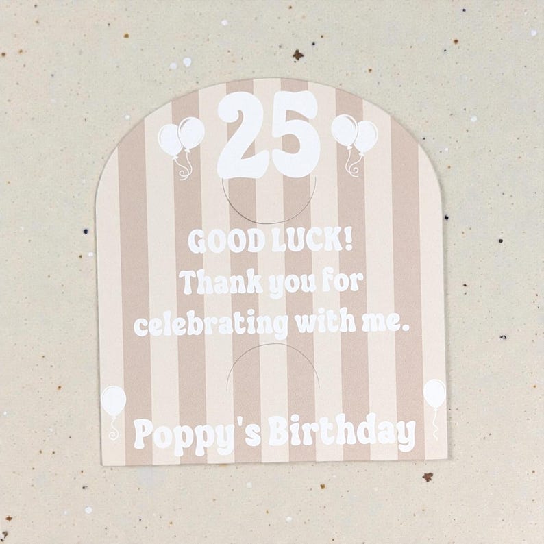 May include: A beige and white striped birthday card with the number 25 in white. The card includes the text "GOOD LUCK! Thank you for celebrating with me. Poppy's Birthday" and white balloon graphics.