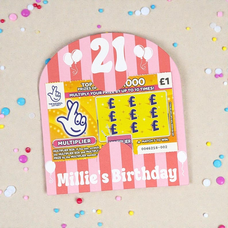 May include: A pink and white birthday card with a scratch-off lottery ticket. The card features the number 21, balloons, and the text "Millie's Birthday." The lottery ticket shows the National Lottery logo and the text "MULTIPLIER."