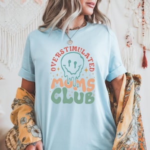 Overstimulated Moms Club T-Shirt – Funny Mom Life Graphic Tee – Relatable Parenthood Humor Shirt – Unisex Tired But Trying Top