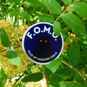 May include: A blue and white sticker with an owl illustration and the text "F.O.M.O. FEAR OF MISSING OWLS".