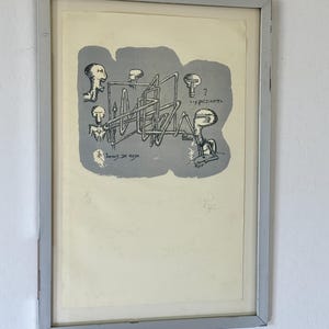 K&ouml;nnte beinhalten: Ein gerahmter Druck mit einer grauen zentralen Form, die schwarze Strichzeichnungen stilisierter Figuren und eine komplexe rohrartige Struktur enth&auml;lt. Der Text lautet "Juegos de mesa" und "...y de dentro". Der Druck ist mit 8/18 nummeriert und signiert.