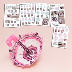 White and pink beaded umbrella in peyote stitch lying on its dome beside printed sheets with example patterns.