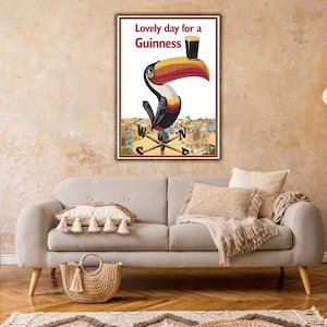 May include: A vintage Guinness advertisement featuring a toucan holding a glass of Guinness with the text "Lovely day for a Guinness".