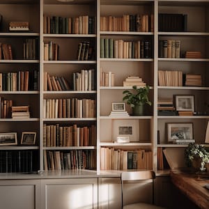 Puede incluir: Una estantería blanca llena de libros en un entorno de oficina en casa. La estantería tiene varios estantes y está en una esquina de la habitación. Hay un escritorio de madera con una lámpara y una silla en la esquina de la habitación.