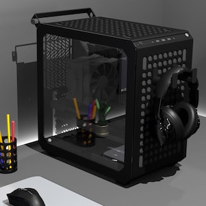 Könnte beinhalten: Ein schwarzes Computergehäuse mit einer transparenten Seitenwand, die interne Komponenten zeigt. Ein schwarzer Kopfhörer hängt an der Seite. Ein Monitor, eine Maus und ein Stifthalter mit farbigen Stiften sind ebenfalls zu sehen.