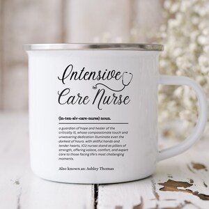 May include: White enamel camping mug with a black and white design that reads "Intensive Care Nurse (in-ten-siv-care-nursa) noun. a guardian of hope and healer of the critically ill, whose compassionate touch and unwavering dedication illuminate even the darkest of hours, with skillful hands and tender hearts, ICU nurses stand as pillars of strength, offering solace, comfort, and expert care to those facing life's most challenging moments. Also known as: Ashley Thomas"