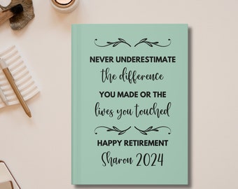 May include: A light green journal with the text "NEVER UNDERESTIMATE the difference YOU MADE OR THE lives you touched HAPPY RETIREMENT Sharon 2024" in black.