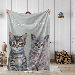 May include: A gray fleece blanket with the text "Simba & Nala" printed in white. Two cats, one tabby and one gray, are pictured on the blanket.