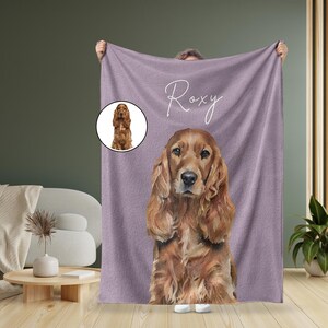 May include: A purple fleece blanket with a personalized name "Roxy" and a picture of a brown cocker spaniel dog.