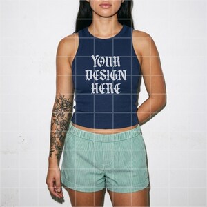 May include: Navy blue tank top with the text "YOUR DESIGN HERE" in white, paired with green and white striped shorts. The top is a fitted style, and the shorts have an elastic waistband.