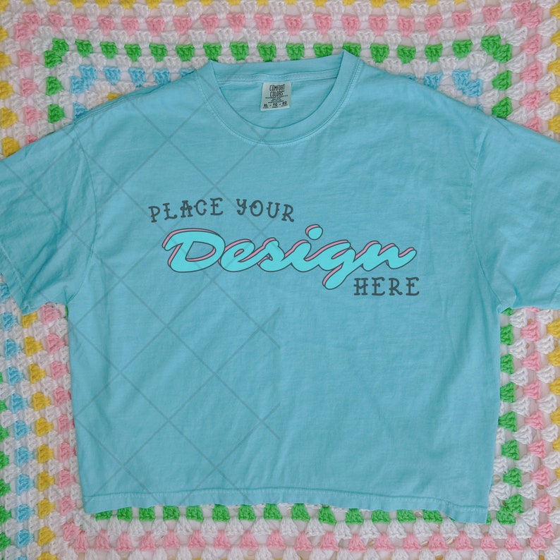 May include: A light blue t-shirt with a white graphic that says "Place Your Design Here" in a retro font.