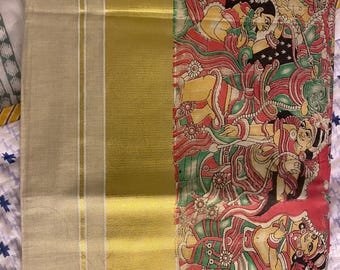 May include: A traditional Indian saree with a gold border and a colourful, hand-painted design featuring figures and floral motifs. The design is vibrant and intricate, showcasing a rich cultural heritage.